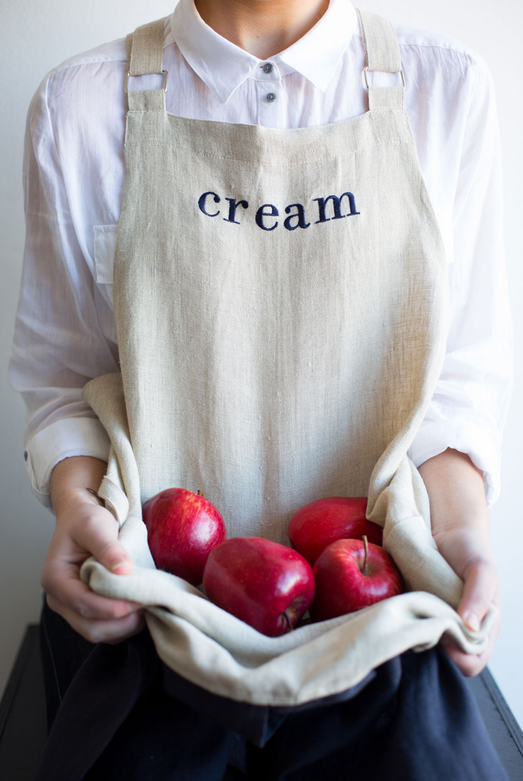 Linen apron cradling red apples