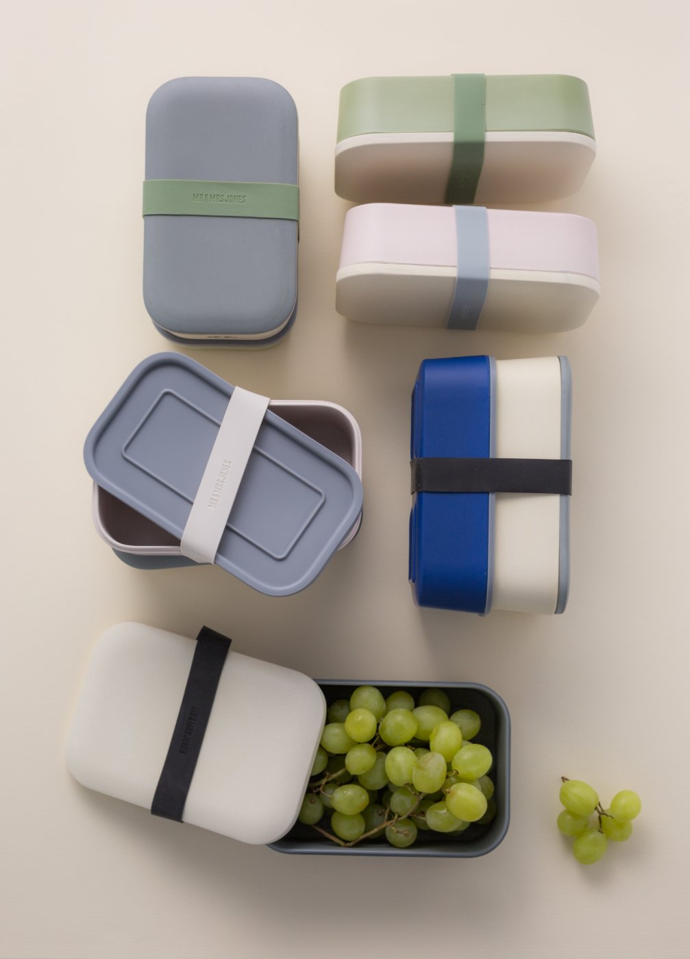 Pastel bento lunch boxes flatlay with grapes