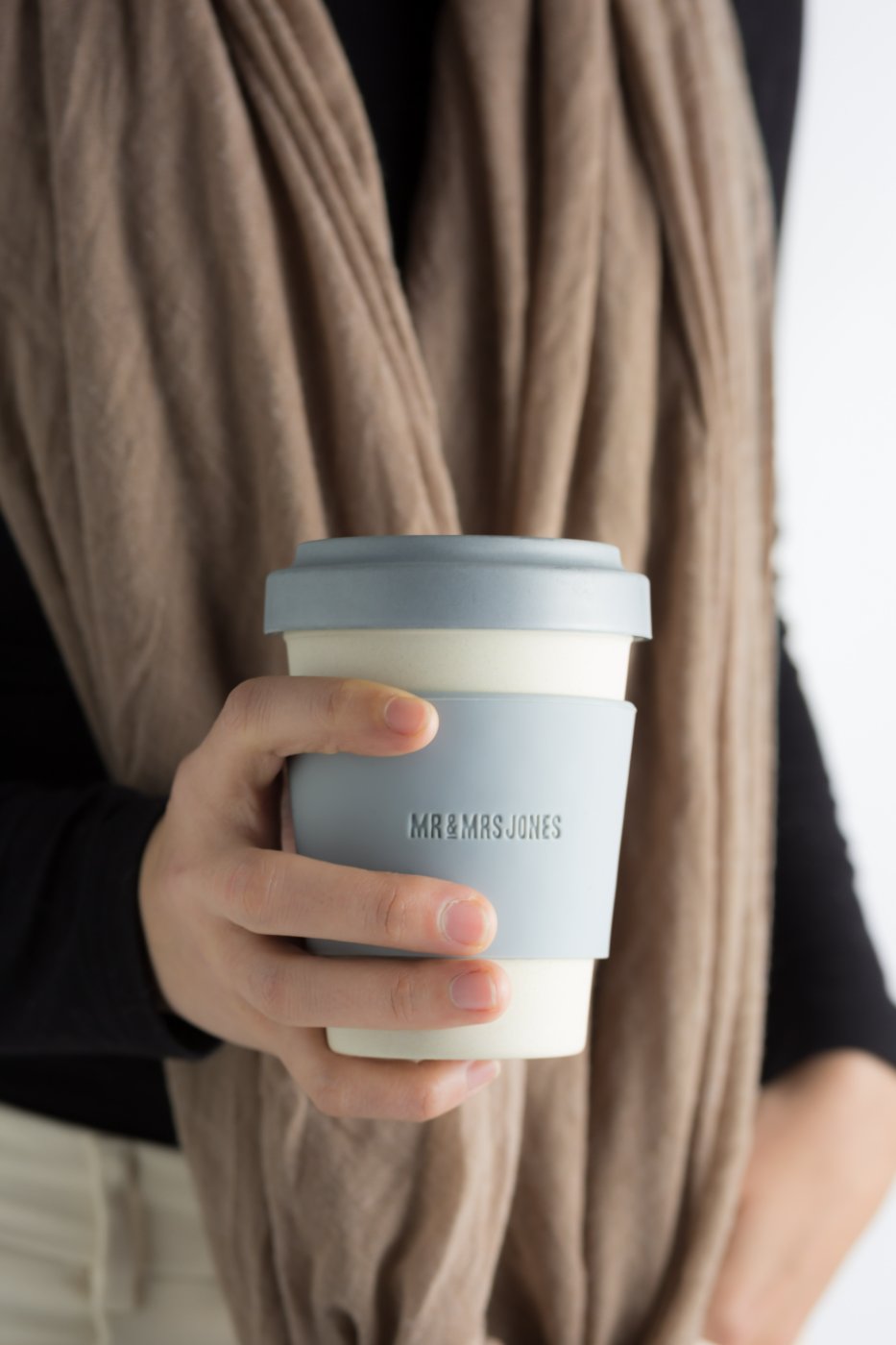 Hand holding Mr and Mrs Jones reusable coffee cup