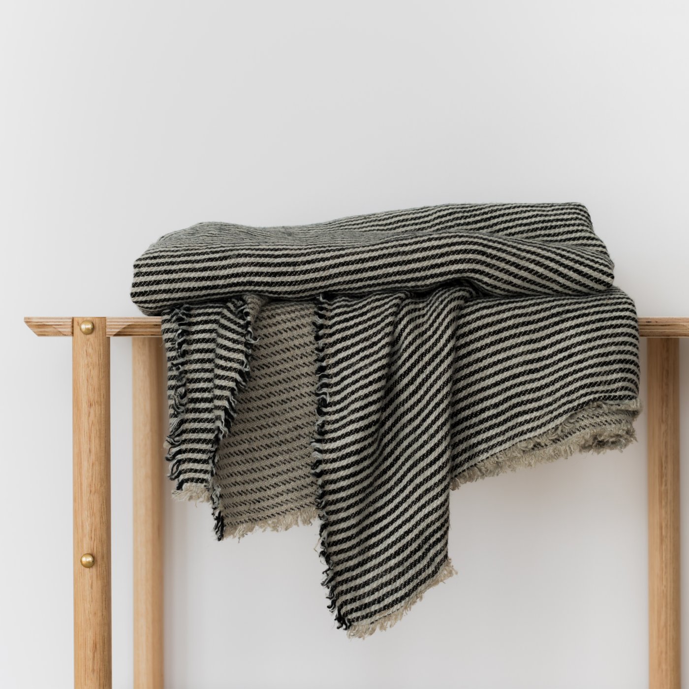 Black and white striped throw on a timber bench